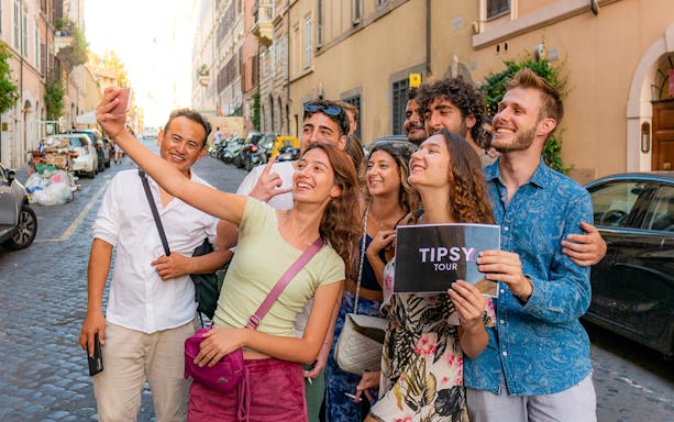 Group taking a selfie on a Rome guided tour in a cobblestone street.