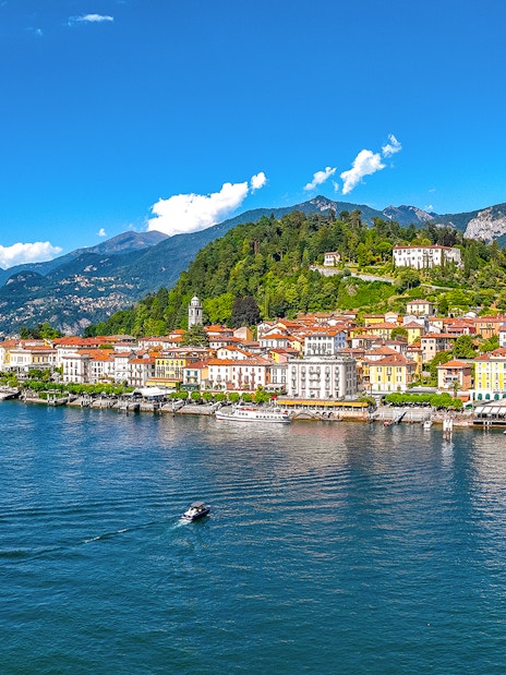 Aerial view of Bellagio village on Lake Como with colorful buildings and surrounding mountains.