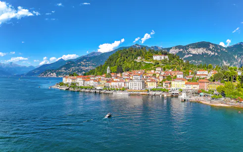 Aerial view of Bellagio village on Lake Como with colorful buildings and surrounding mountains.