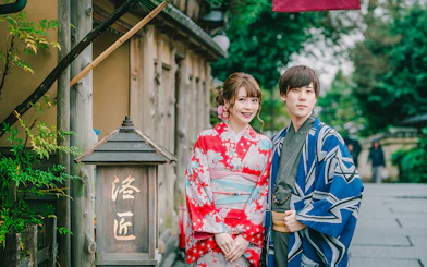 Couple in traditional kimonos posing on a street in Japan.