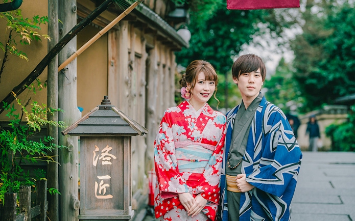 Couple in traditional kimonos posing on a street in Japan.