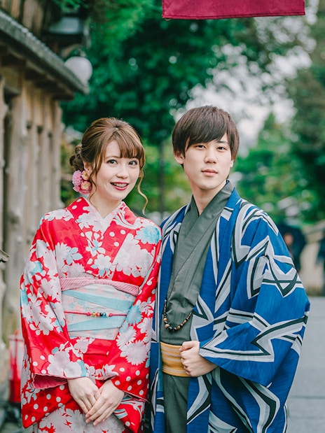 Couple in traditional kimonos posing on a street in Japan.