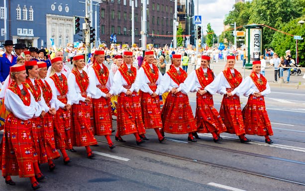 Performers in traditional red costumes at Tallinn Song Festival parade.