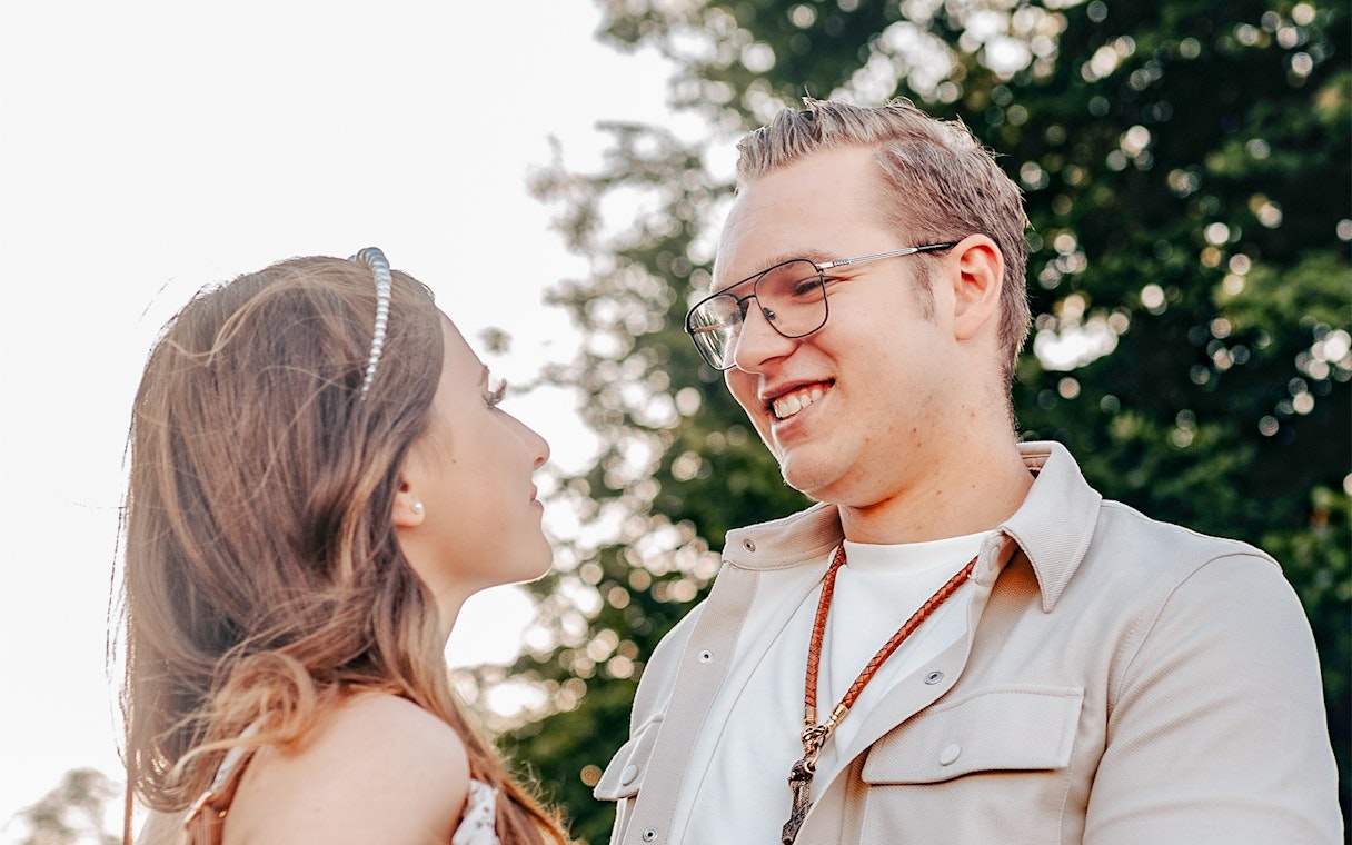 Couple smiling during a photoshoot at Magere Brug, Amsterdam.