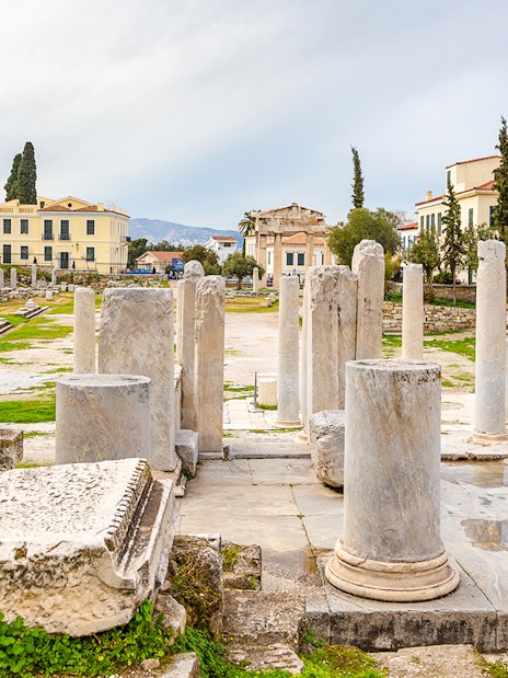 Roman Agora ruins with columns in Athens, Greece, surrounded by historic buildings.
