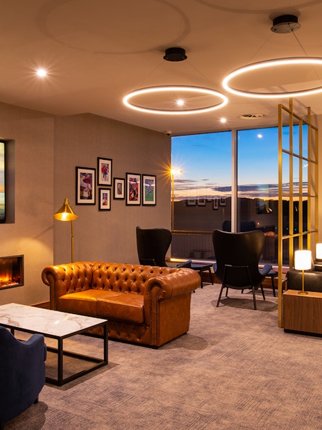 Plaza Premium Lounge seating area with leather sofas and large windows at Edinburgh Airport.