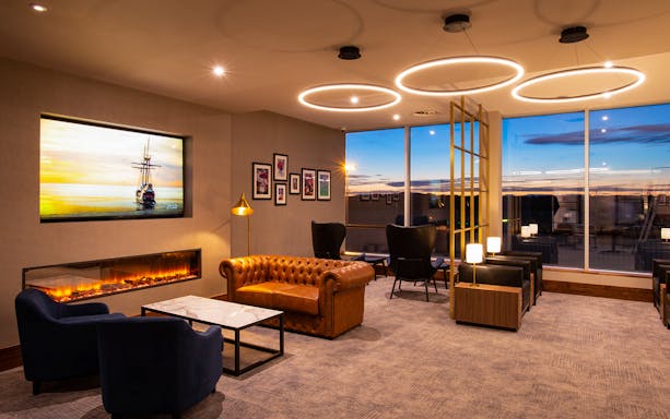 Plaza Premium Lounge seating area with leather sofas and large windows at Edinburgh Airport.