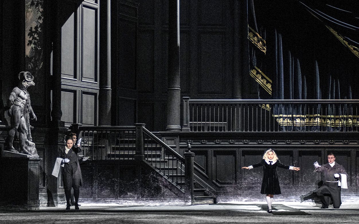 Opera performers on stage during a scene from "Salome" with dramatic lighting and set design.