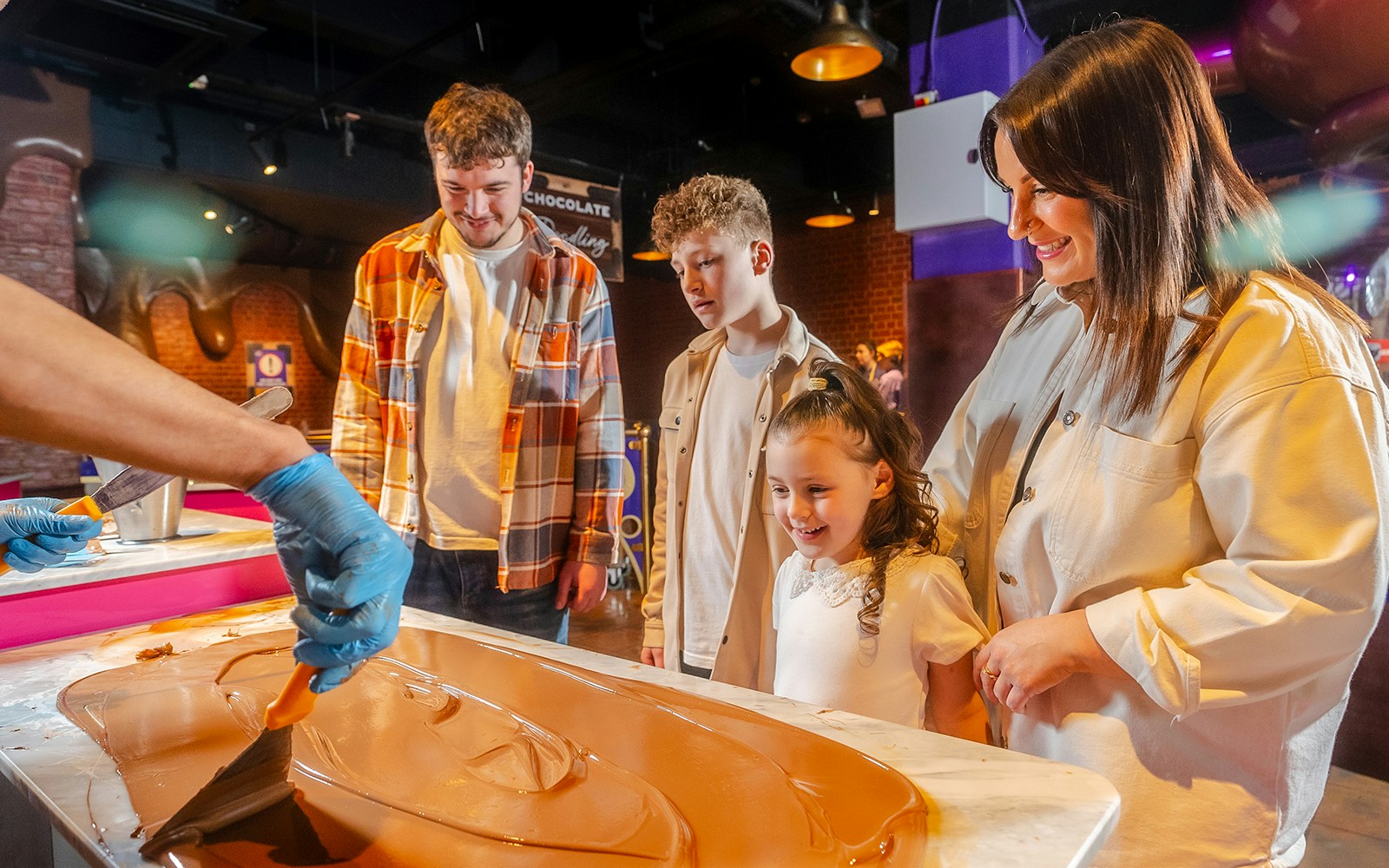 Visitors watching chocolate being spread at Cadbury World.