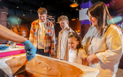 Visitors watching chocolate being spread at Cadbury World.