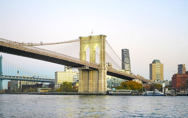 Brooklyn Bridge over East River with Manhattan skyline in the background.