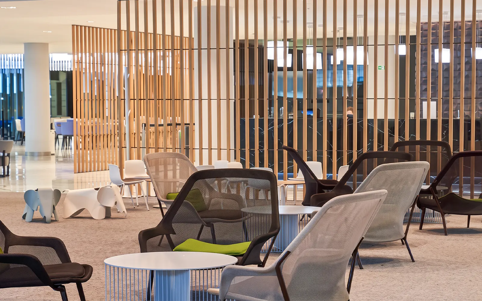 Seating area in Sala VIP Joan Miro at Barcelona El Prat Airport T1 with modern chairs and tables.