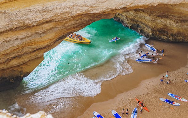 Benagil Caves tour with kayakers and boat in Algarve, Portugal.