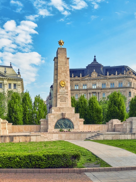 Soviet War Memorial in Liberty Square, Budapest, surrounded by historic buildings.