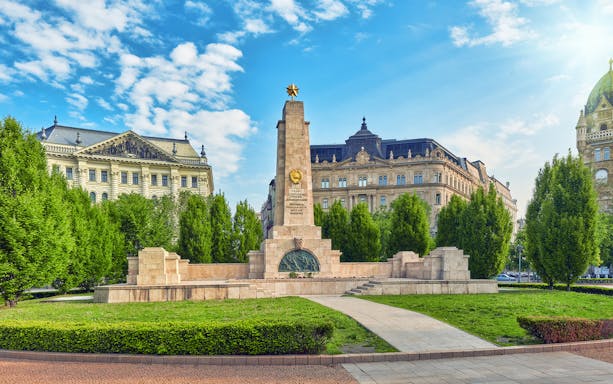 Soviet War Memorial in Liberty Square, Budapest, surrounded by historic buildings.