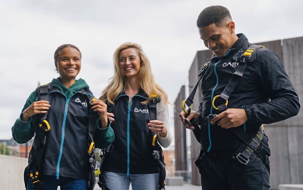 Participants preparing for Dare Skywalk experience with safety harnesses.