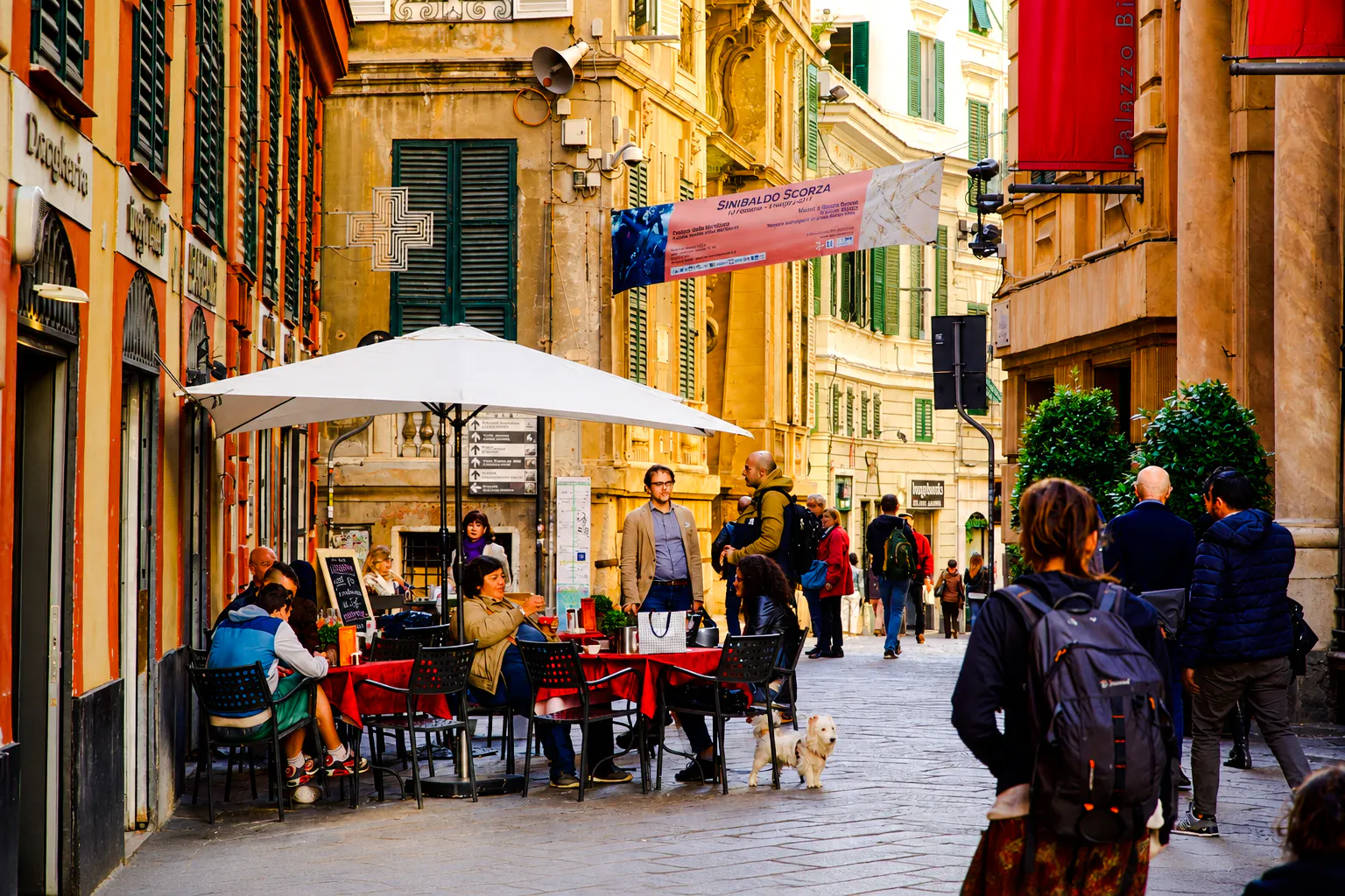 Outdoor dining scene on a street in Genoa during a walking dinner tour.