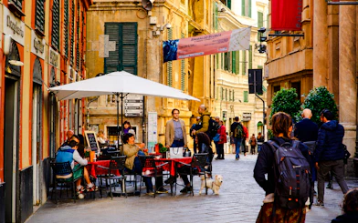 Outdoor dining scene on a street in Genoa during a walking dinner tour.