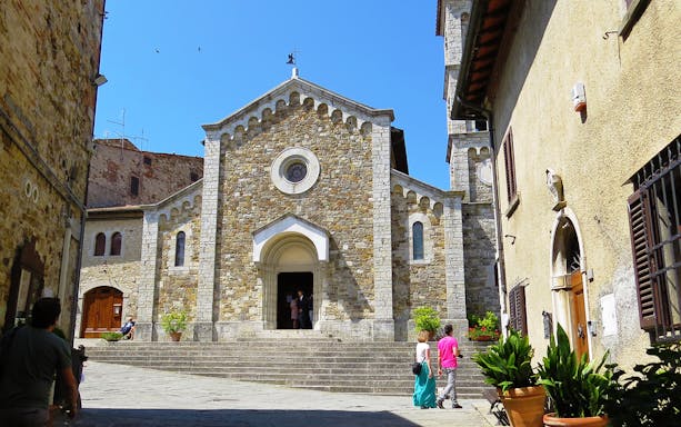Stone church facade in a Tuscan village, part of the Essence of Tuscany tour.