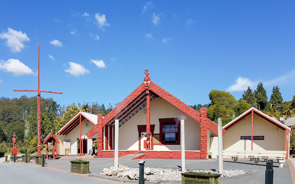 Whakarewarewa Maori meeting house with carved red details, New Zealand.