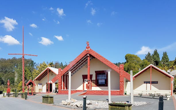Whakarewarewa Maori meeting house with carved red details, New Zealand.