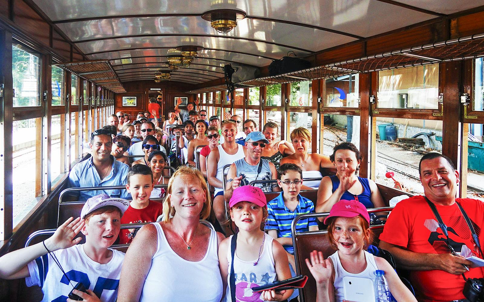 Passengers enjoying a vintage train ride during a Mallorca sightseeing tour.