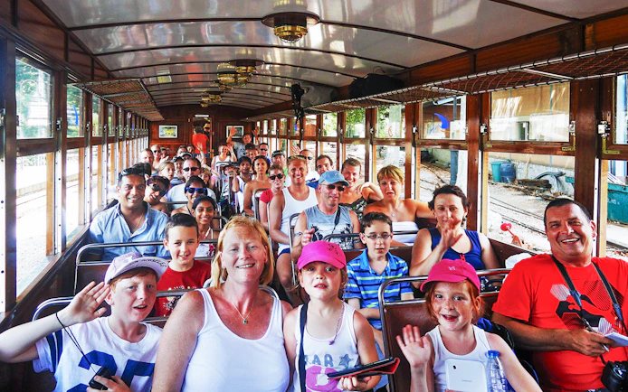 Passengers enjoying a vintage train ride during a Mallorca sightseeing tour.
