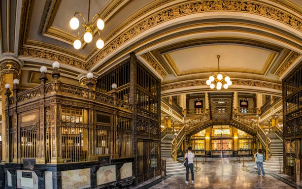 Interior of the ornate Postal Palace in Mexico City with grand staircase and decorative details.