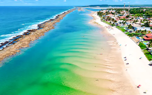 Aerial view of Praia do Francês beach with turquoise waters and sandy shoreline in Maceió, Brazil.