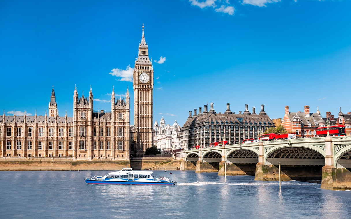 Thames River cruise boat near Big Ben and Westminster Bridge, London.