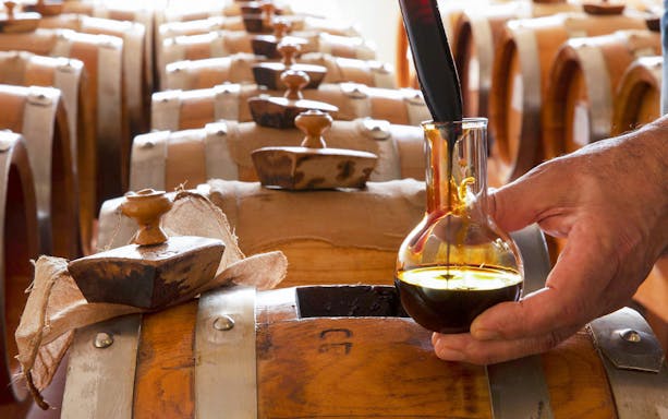 Balsamic vinegar being poured from a barrel at Acetaia La Vedetta in Modena.