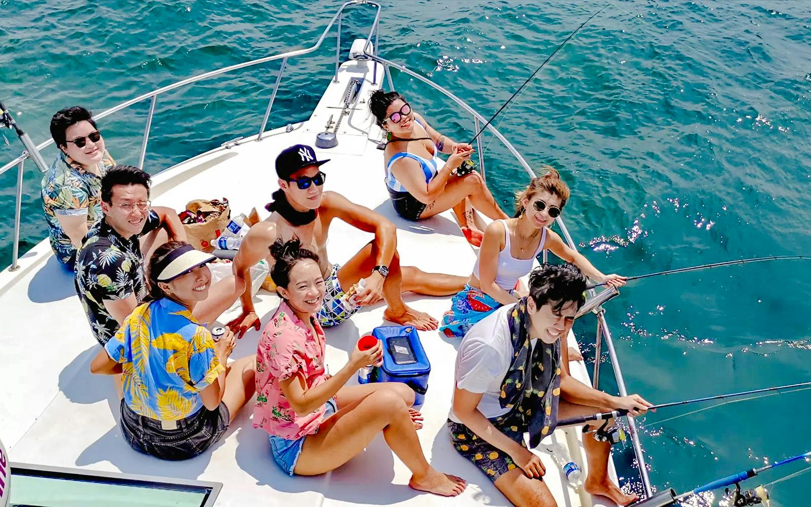 Group enjoying yacht fishing trip on open sea.