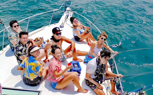 Group enjoying yacht fishing trip on open sea.