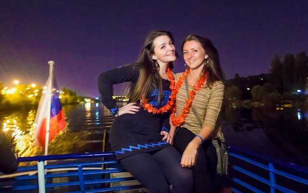 Two people enjoying a night boat party on the Vltava River in Prague.