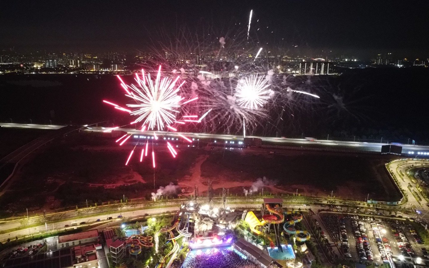 Fireworks display over SplashMania Waterpark at night, highlighting the Night Splash event.