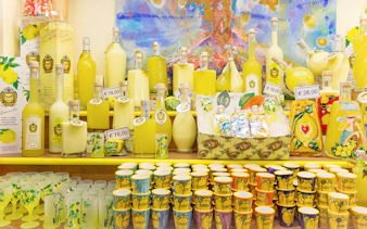 Limoncello bottles and souvenirs on display in a shop in Positano, Italy.