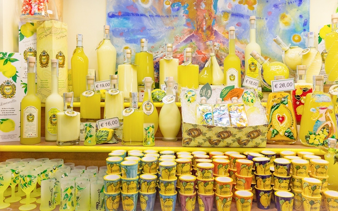 Limoncello bottles and souvenirs on display in a shop in Positano, Italy.
