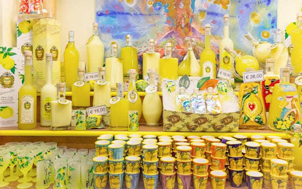 Limoncello bottles and souvenirs on display in a shop in Positano, Italy.