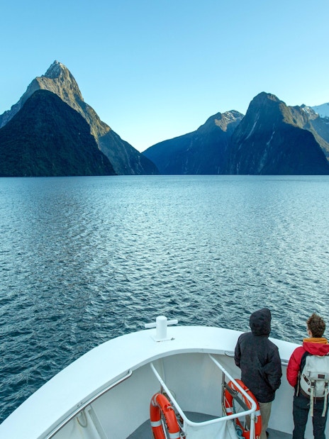 People enjoying a scenic cruise on Doubtful Sound, Queenstown, surrounded by lush mountains.