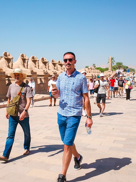 Tourists walking along the Avenue of Sphinxes at Luxor Temple, Egypt.