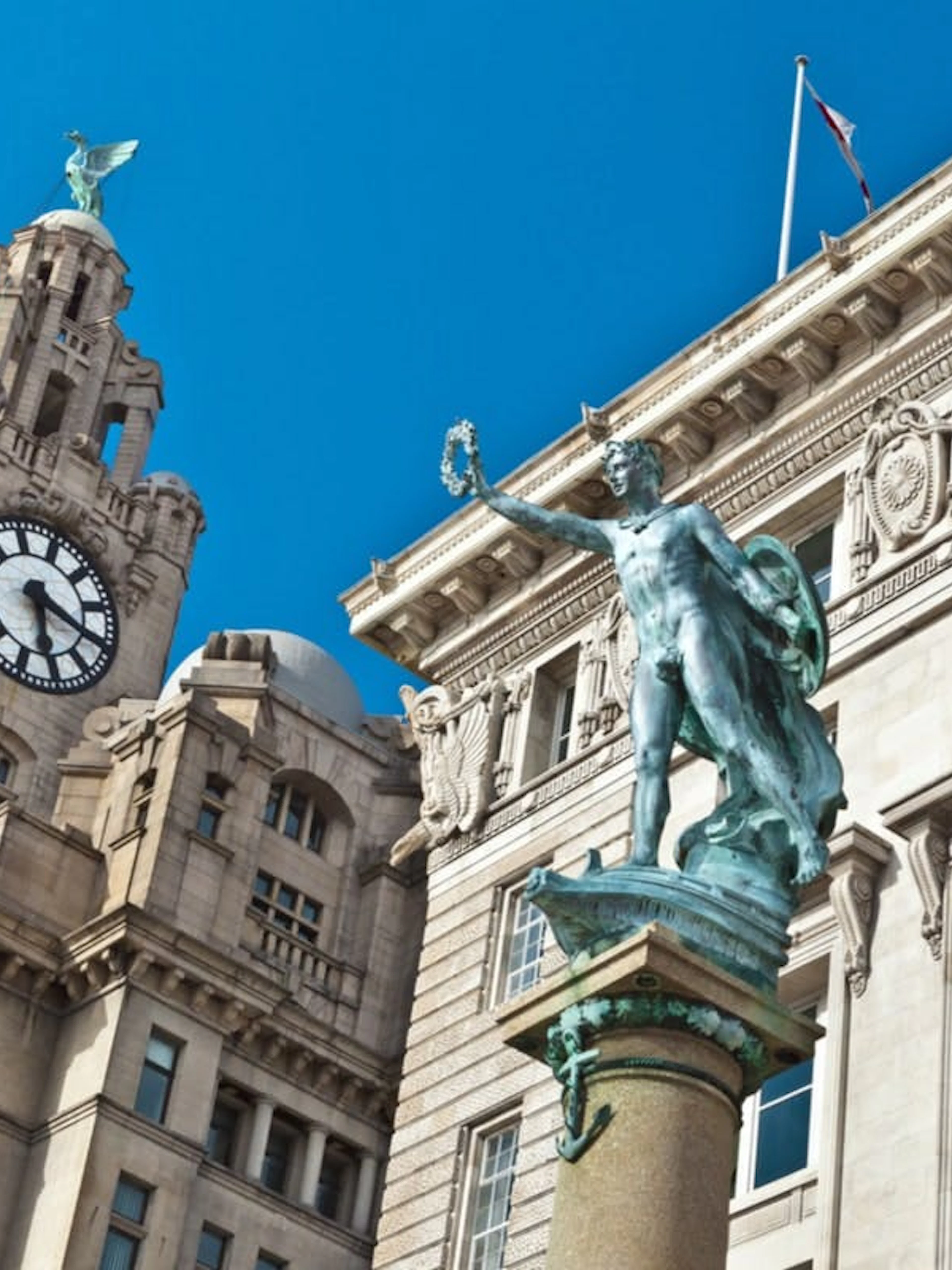 Liver Building clock tower and statue in Liverpool city center.