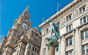 Liver Building clock tower and statue in Liverpool city center.