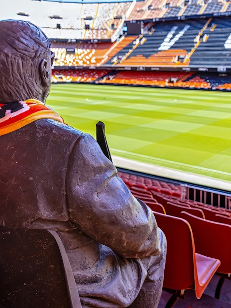 Statue with scarf overlooking Mestalla Stadium seats and field, Valencia CF.