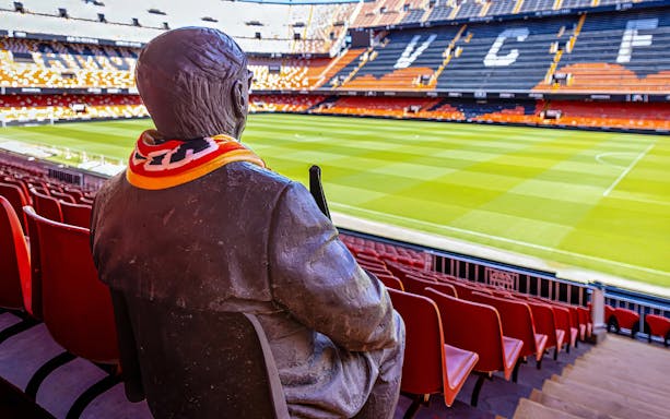 Statue with scarf overlooking Mestalla Stadium seats and field, Valencia CF.