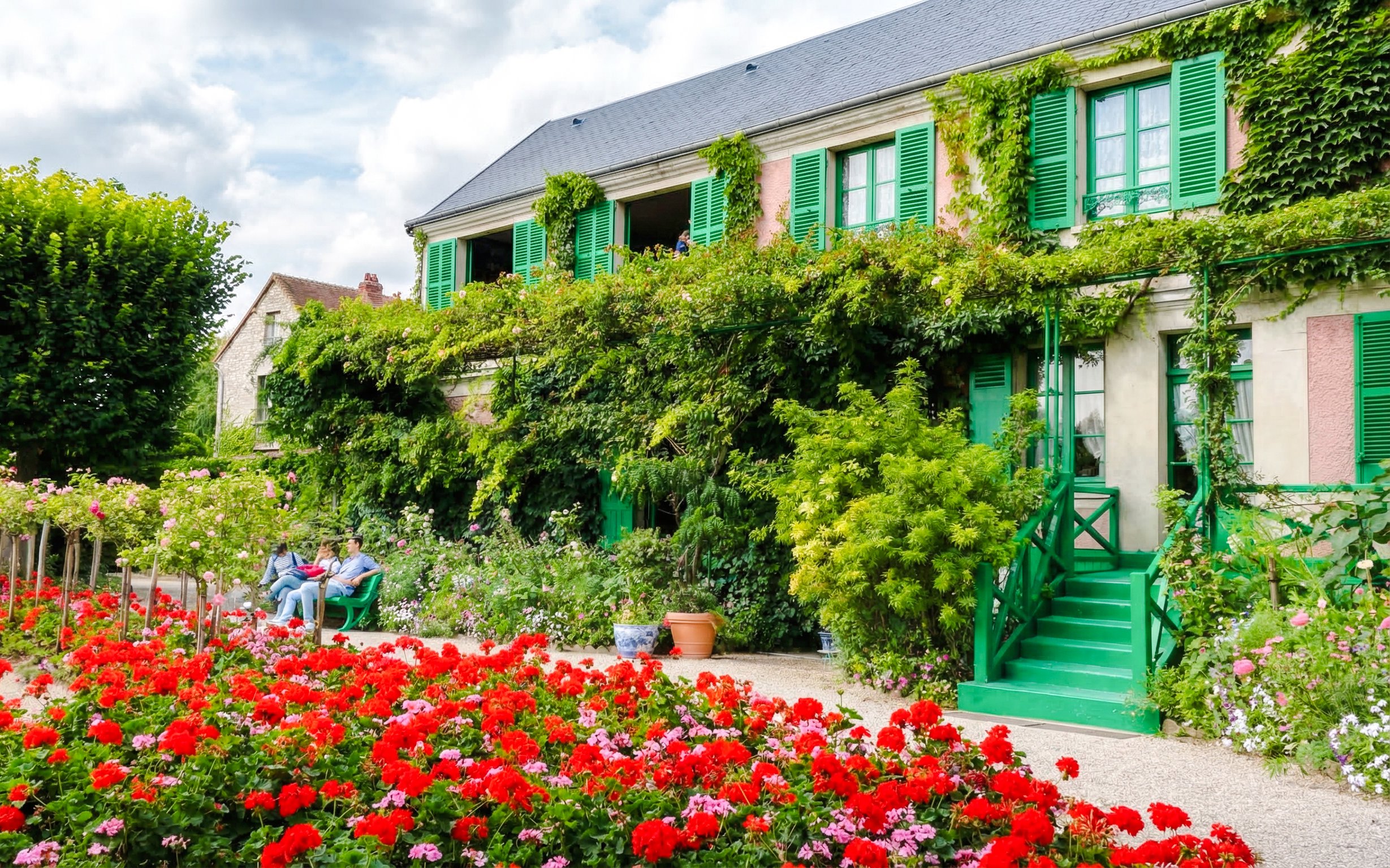 Claude Monet’s home with vibrant gardens in Giverny, featuring lush greenery and colorful flowers.