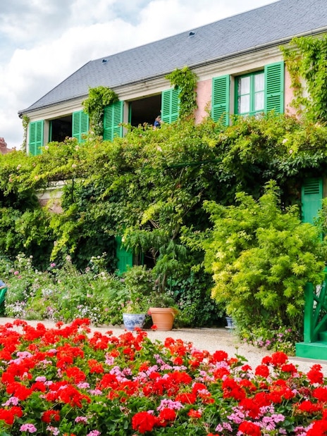 Claude Monet’s home with vibrant gardens in Giverny, featuring lush greenery and colorful flowers.