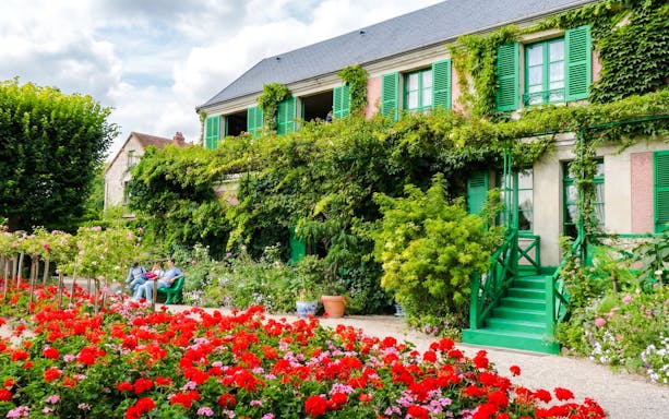 Claude Monet’s home with vibrant gardens in Giverny, featuring lush greenery and colorful flowers.