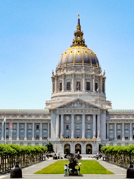 San Francisco City Hall with flags and trees in Civic Center, California.