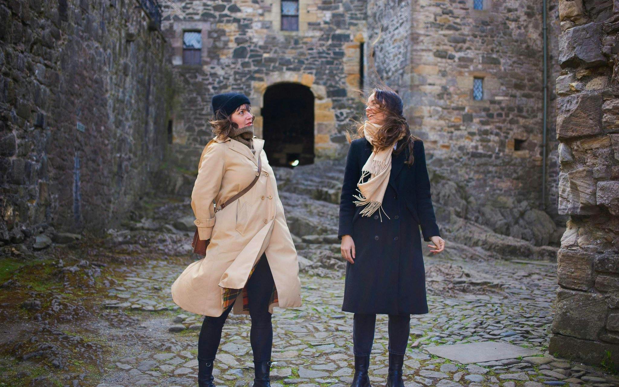 Two people standing in the courtyard of Doune Castle, Scotland.
