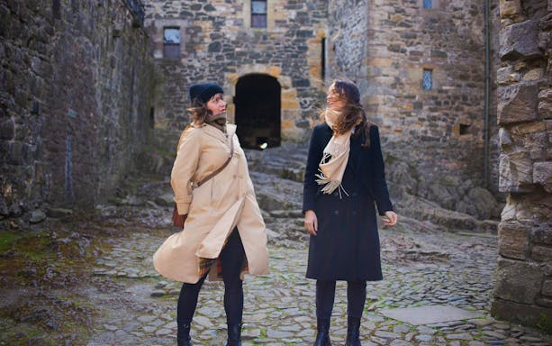 Two people standing in the courtyard of Doune Castle, Scotland.